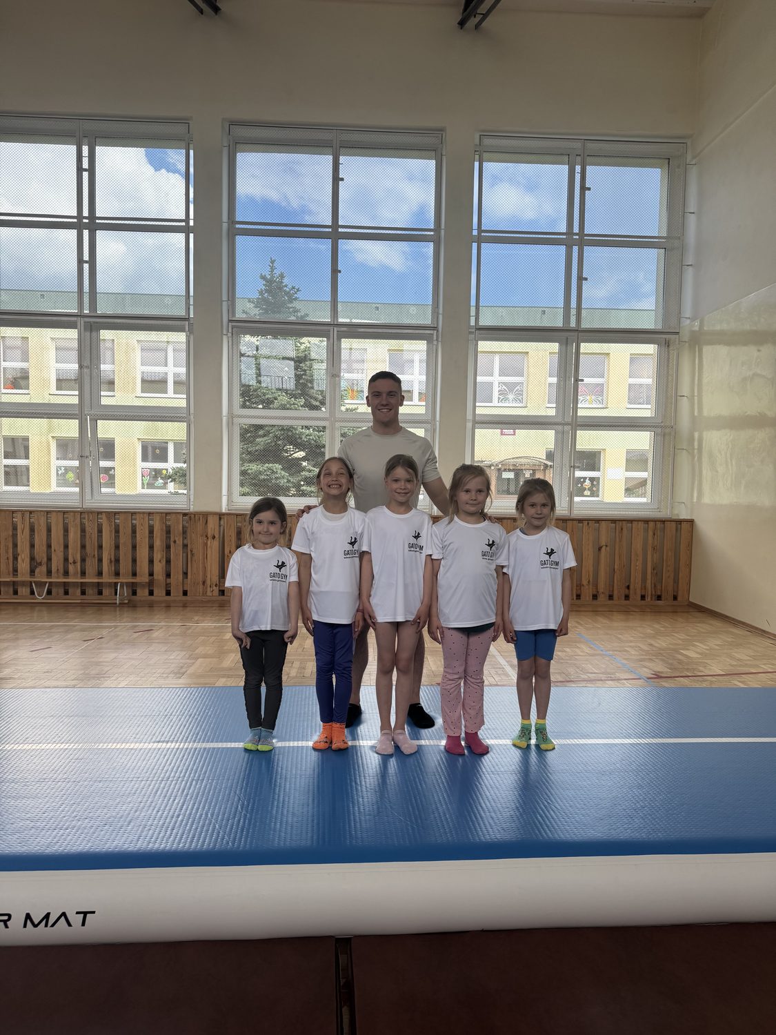 Trener Gato Gym z młodszą grupą zawodniczek